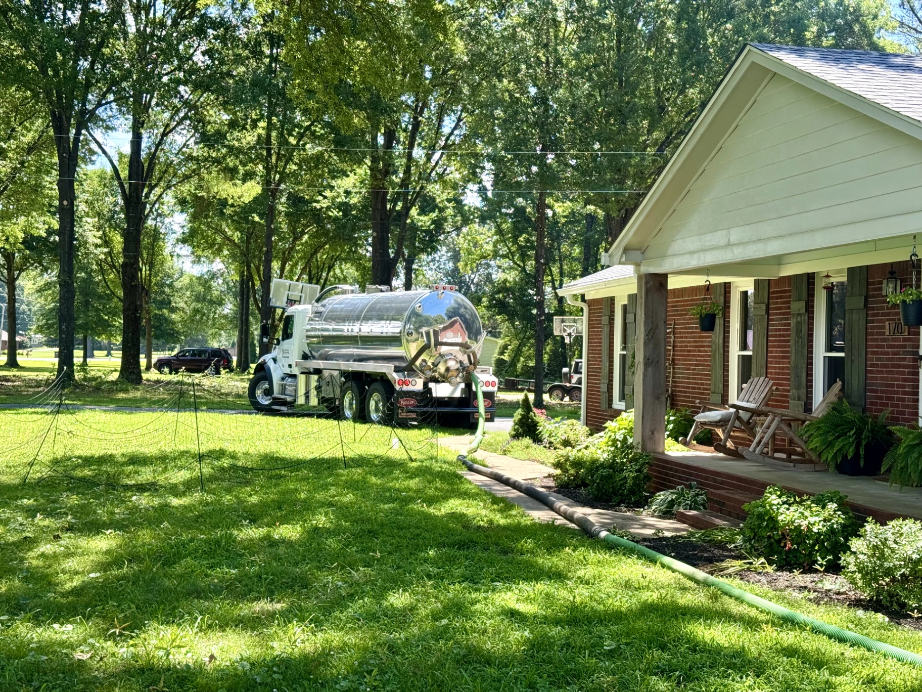 Open septic tank during pumping service in a residential yard