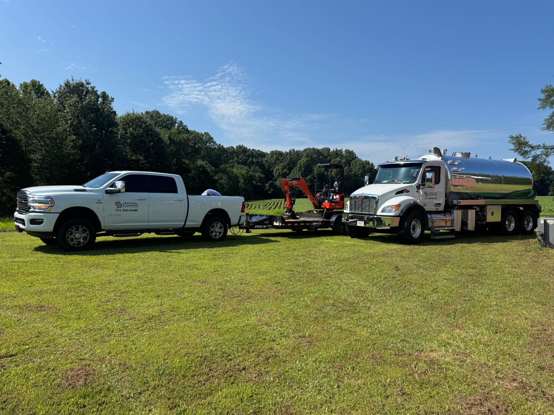 Central Pumping Services fleet with service pickup truck, trailer excavator, and septic pump truck in a West Tennessee field