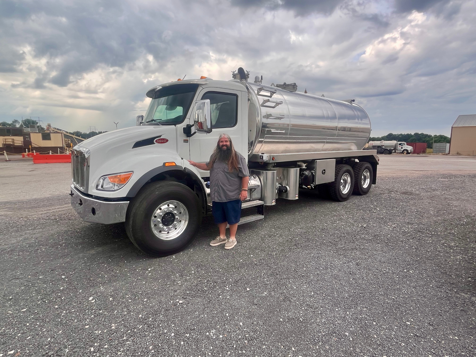 Owner of Central Pumping Services standing beside the company Peterbilt septic pump truck